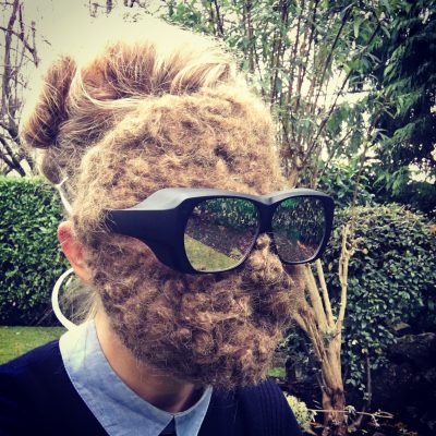 Carollyne wearing her needle felted hair mask and dichromatic spectacles in the garden