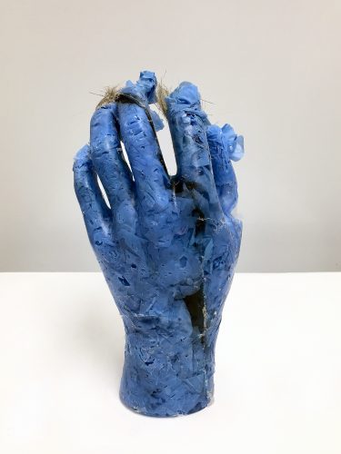 Becoming Plastic Hand, 2022. Human hair, used blue nitrile gloves, resin, 5.5” x 6” x 3”.