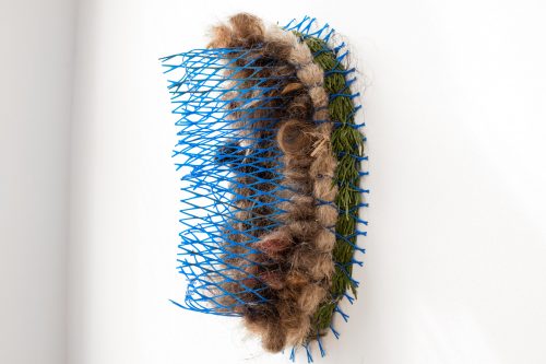 Molecular (front view), from the Symbiogenesis series, 2020. Found and foraged cedar  bough (sustainably harvested after windstorm), pampas grass, human hair, plastic mesh tree protector, 17′′ x 10′′ x  8′