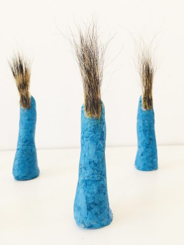 Becoming Plastic Fingers, 2022. Human and squirrel hair, used blue nitrile gloves, resin, acrylic nail, (each finger 3.5″ x .5″ x .5″), 24″ x 10″ x 2″.